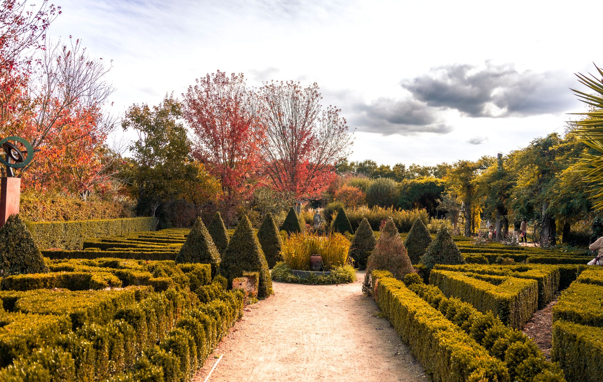 Beautifully landscaped garden in autumn, featuring a well-organized hedge maze and colorful trees.