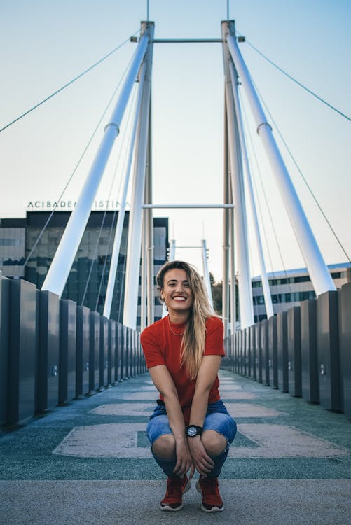 Free Woman Sitting on the Middle of the Bridge Stock Photo
