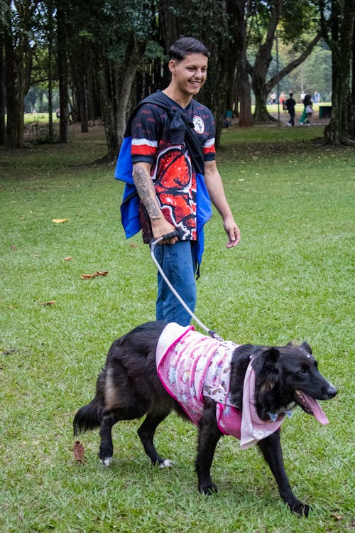Man Walking the Dog in a Park and Smiling 