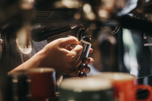 Close-up of a barista's hands expertly using a coffee machine to prepare espresso.
