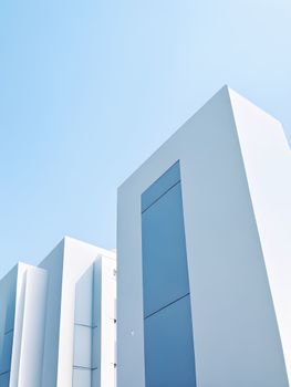 Sleek modern architecture in bright sunlight highlights minimalist design against a clear blue sky.