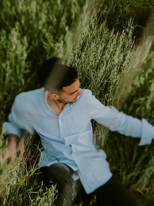 Man in Shirt Sitting on Grassland