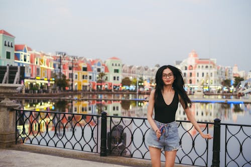 Woman with Long, Black Hair Posing by Water in Town 
