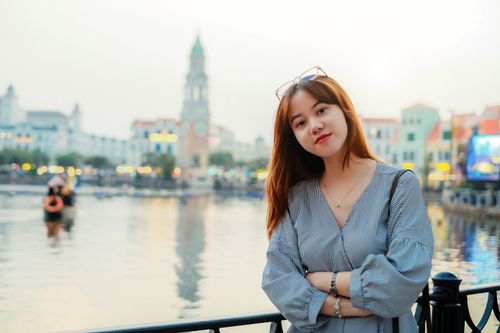 Free Young woman with long hair posing by a scenic urban waterfront. Stock Photo