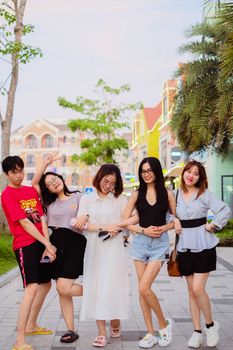 A cheerful group of friends posing together on a sunny day in an urban street, embodying joy and friendship.