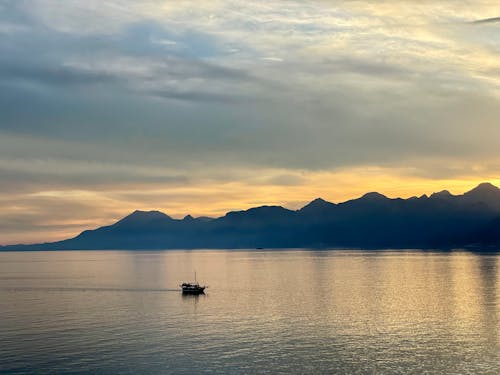 Безкоштовне стокове фото на тему «гори, Захід сонця, катання на човнах»