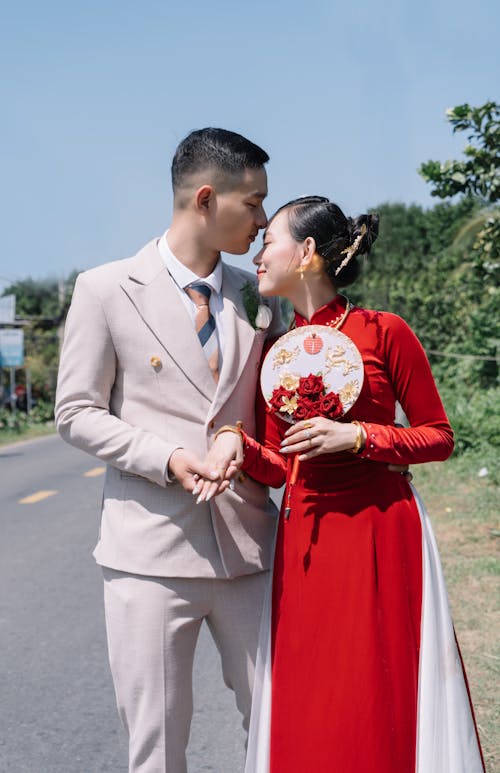 Woman in Dress and Man in Suit Posing on Road