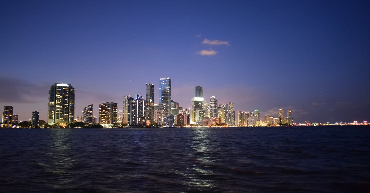 Breathtaking view of Miami's skyline reflecting on Biscayne Bay at twilight.