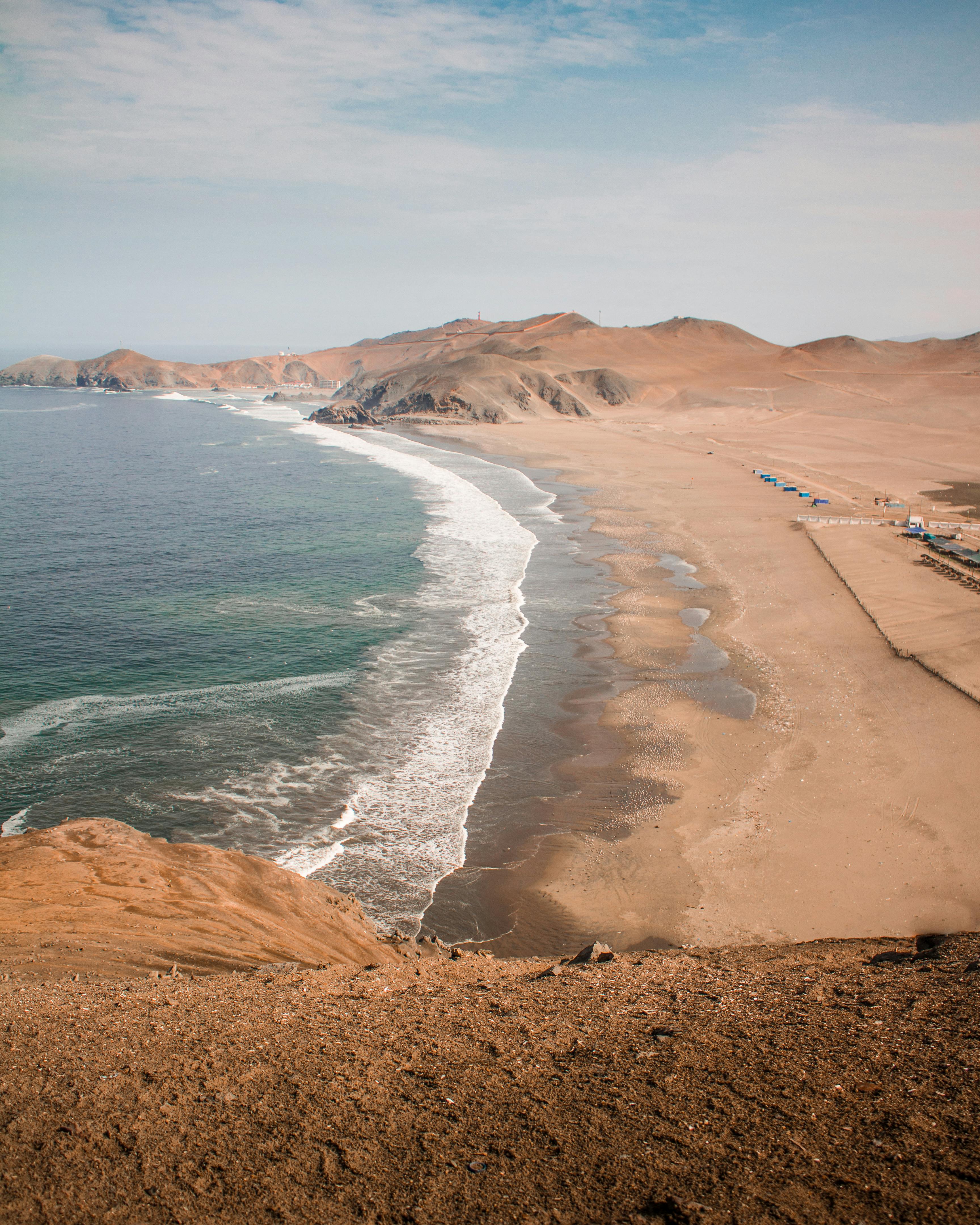 Explore the stunning desert coastline of Lima, Peru, with sandy beaches and ocean waves.