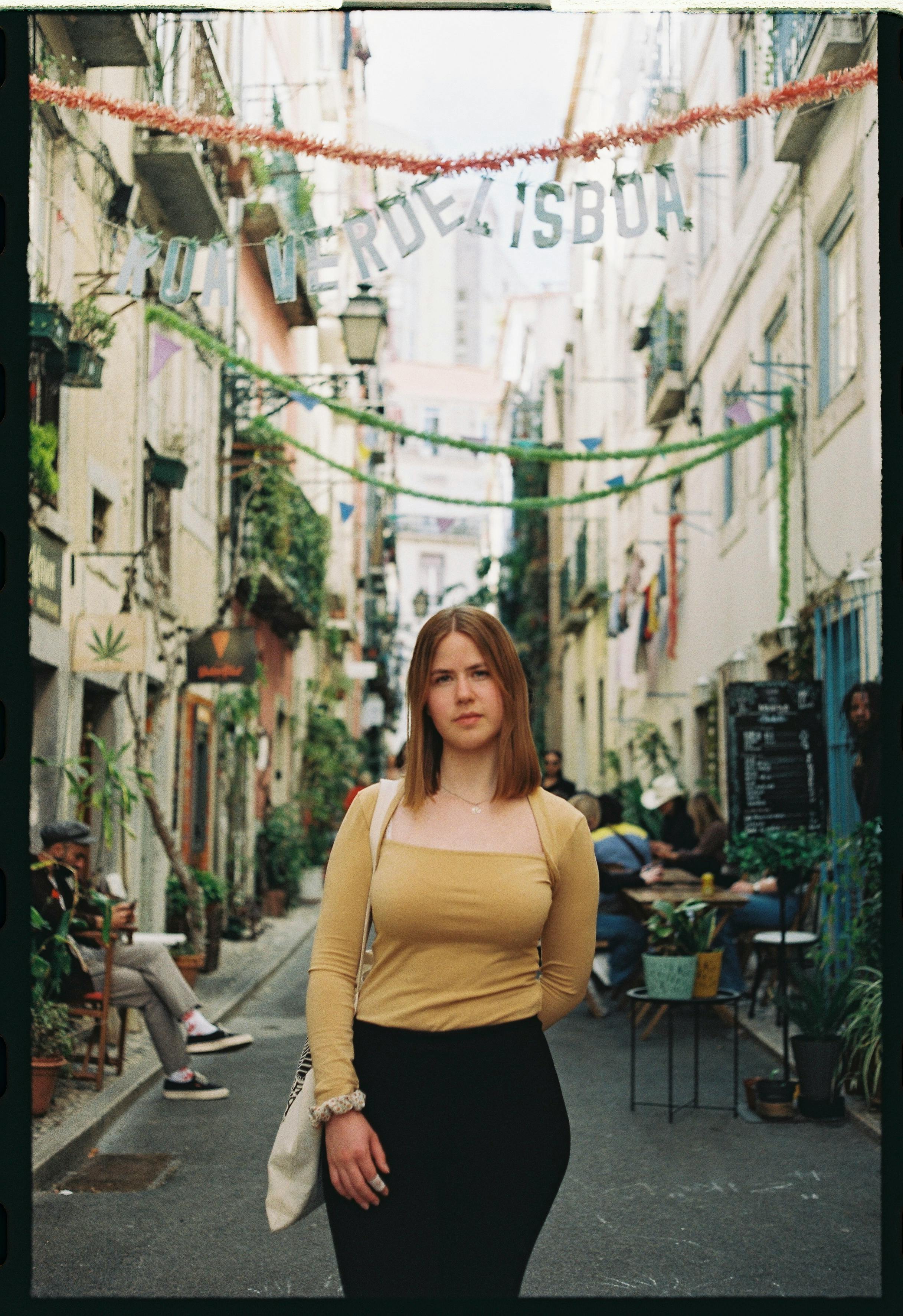 Captivating portrait of a woman in a colorful alley in Lisbon. Urban vibe.