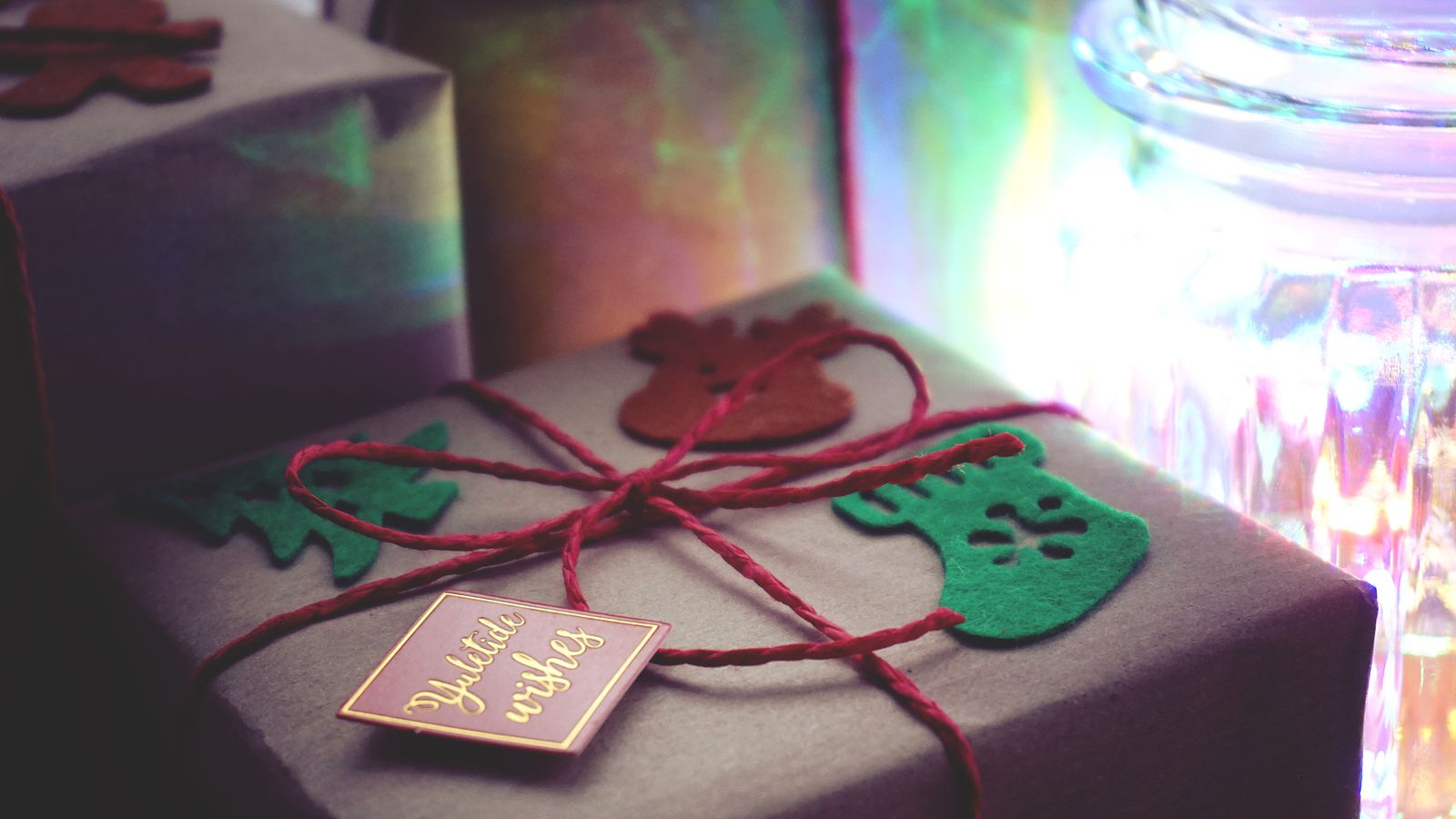 Close-up of Christmas presents with creative decorations and warm lighting indoors.