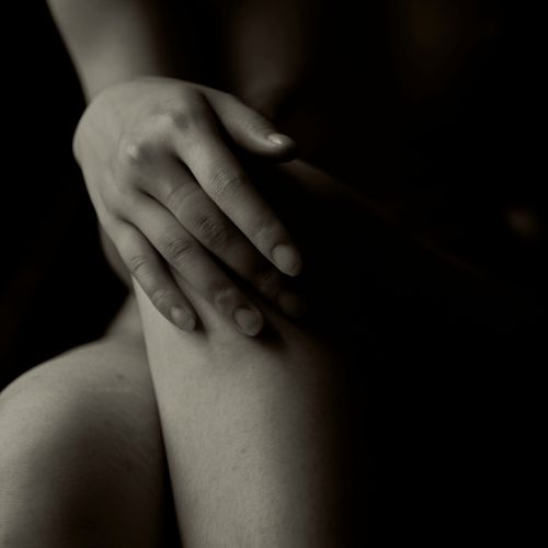 Free Artistic close-up of hands on knee in elegant black and white monochrome style. Stock Photo
