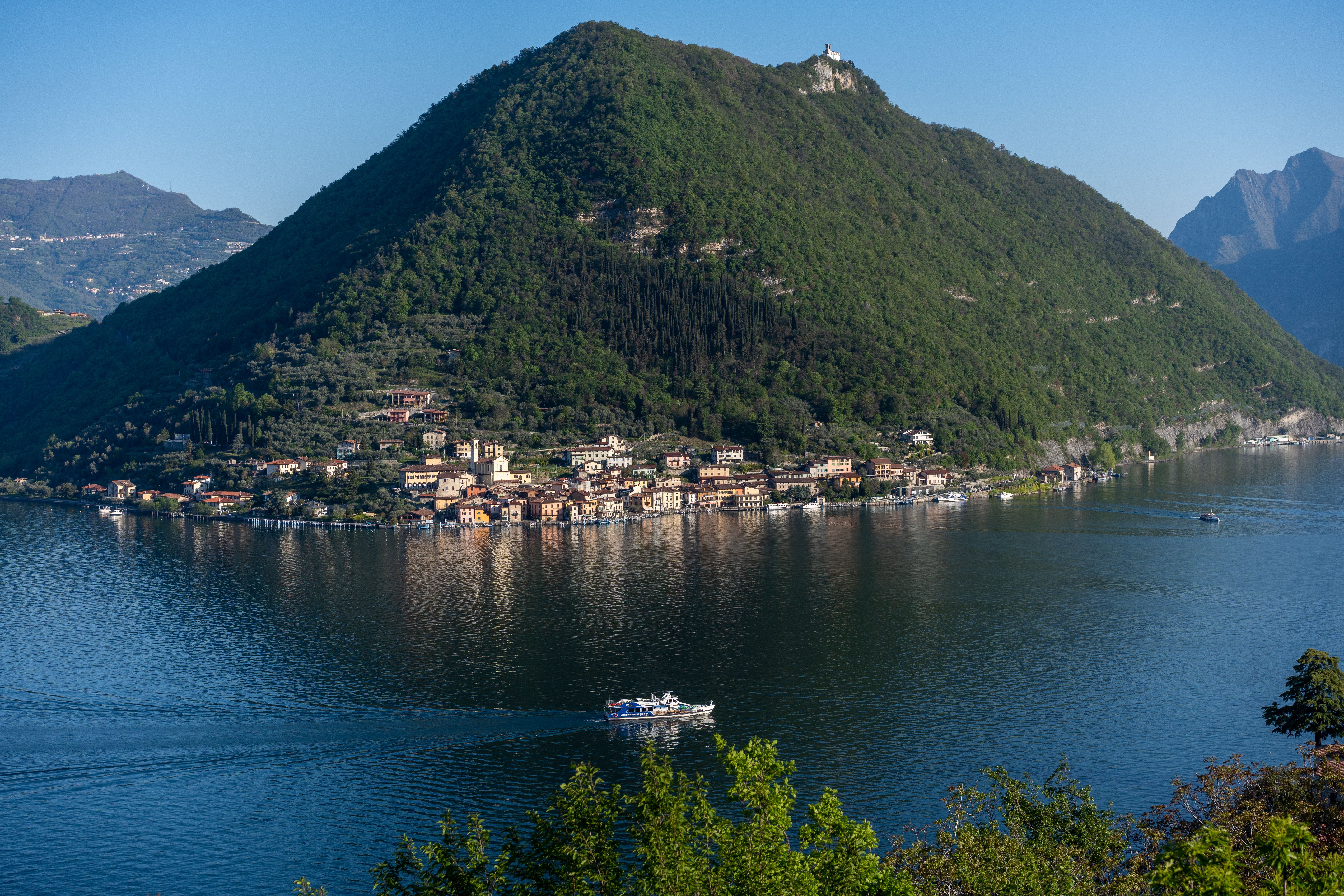 Aerial view of Peschiera Maraglio on Monte Isola, surrounded by Lake Iseo, Lombardy, Italy.