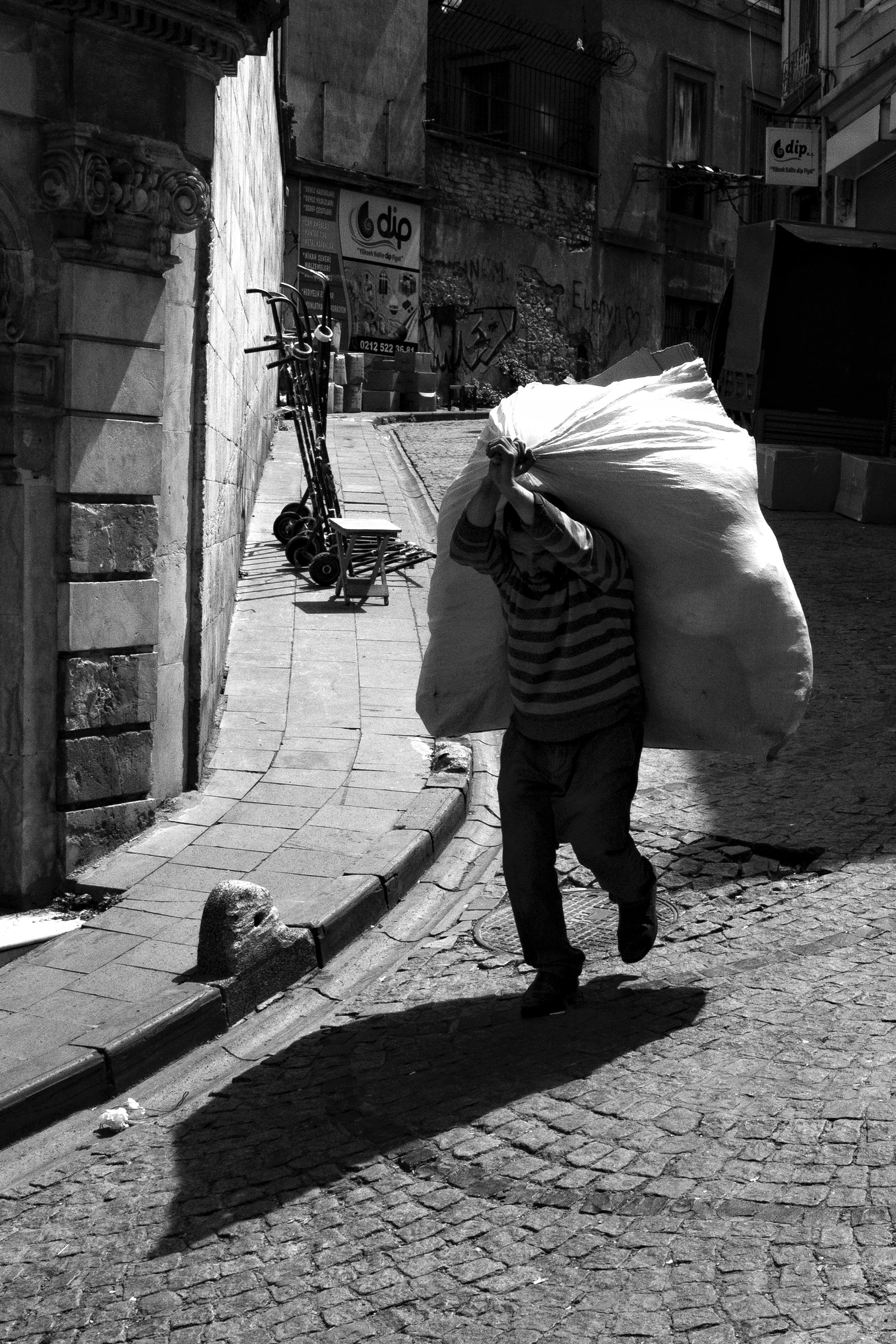 Man Carrying Bag on Street in Black and White · Free Stock Photo