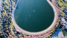 这张令人惊叹的航拍照片，拍摄了迪拜公园内一个郁郁葱葱的圆形湖泊，公园里还有蜿蜒的小路和绿地