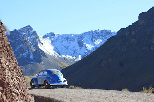 Old Volkswagen Beetle on the Road Through the Mountains