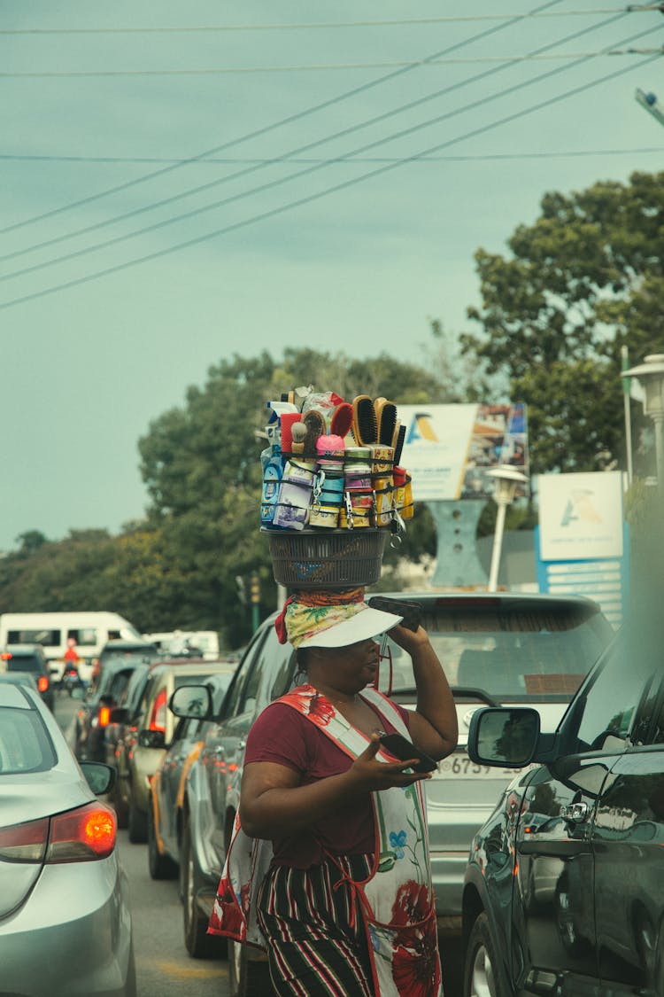 Woman Carrying Bucket On Head On Street