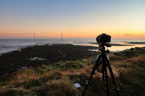 Black Camera With Tripod  Near Body of Water