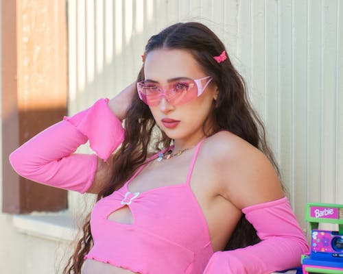 Female Model Wearing a Pink Crop Top and Sunglasses