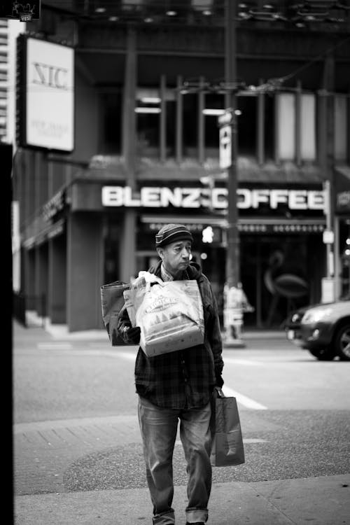 Free Man with Bags Walking near Street Stock Photo