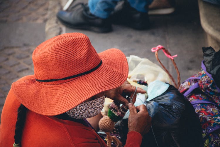 Elderly Woman Knitting On The Street 