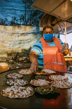 A woman prepares traditional Mexican pizzas at a street market in Guanajuato, Mexico.