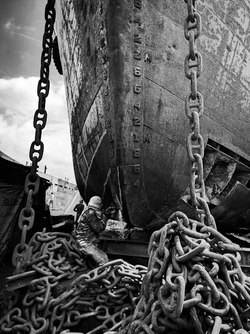 Man Cutting the Hull of a Ship