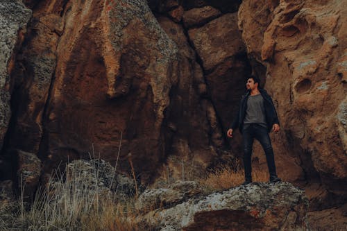 Man Standing in front of a Rock Formation 