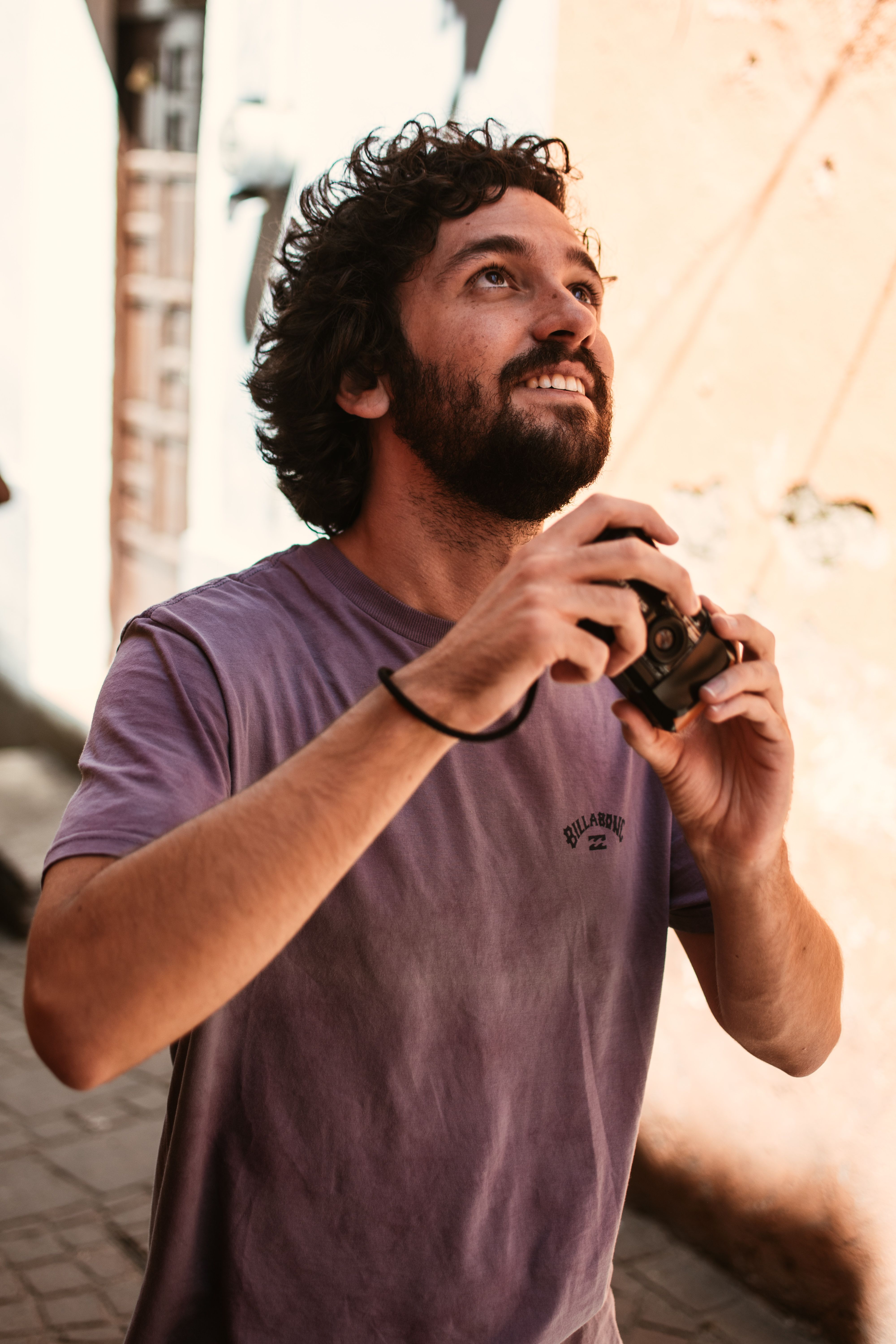 Man in Guanajuato holding camera, capturing vibrant street views.