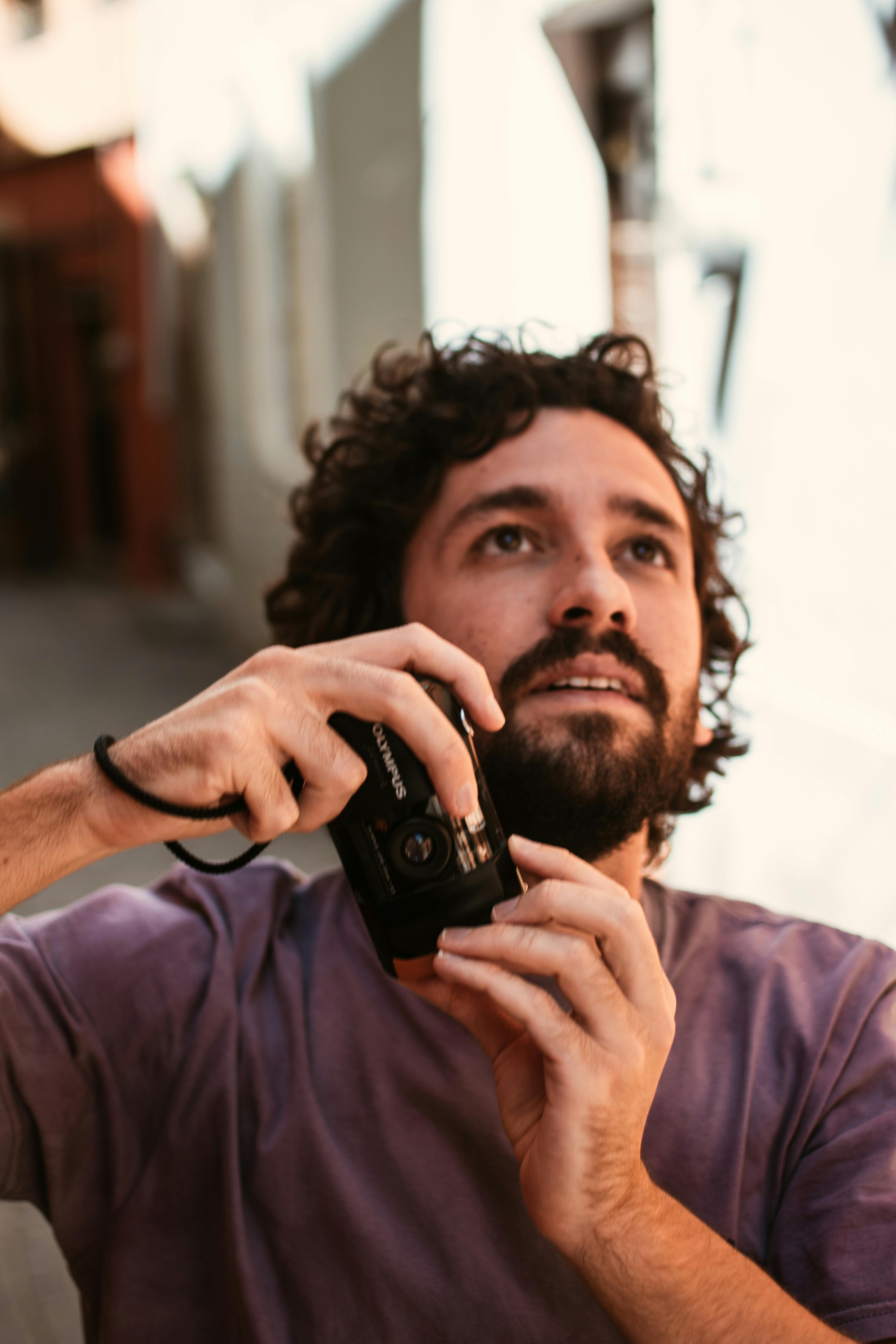 Man holding a camera, capturing moments in Guanajuato's vibrant streets.