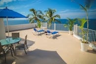 放松的海滨露台，配有躺椅，在蓝天下欣赏海景