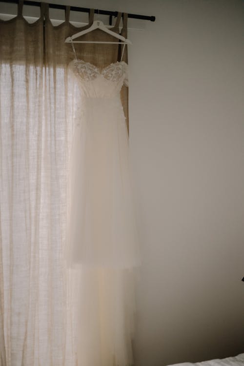 Wedding Dress Hanging over Curtain