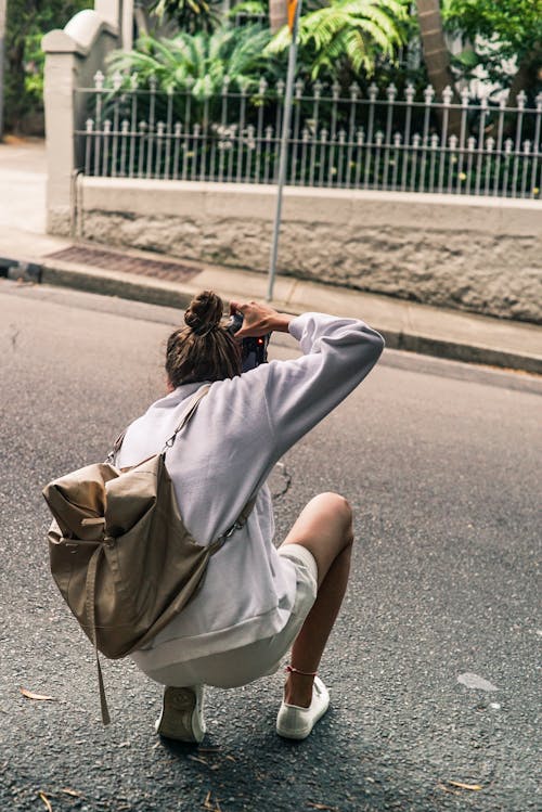 Free Person Kneeling on Road While Taking Picture Stock Photo