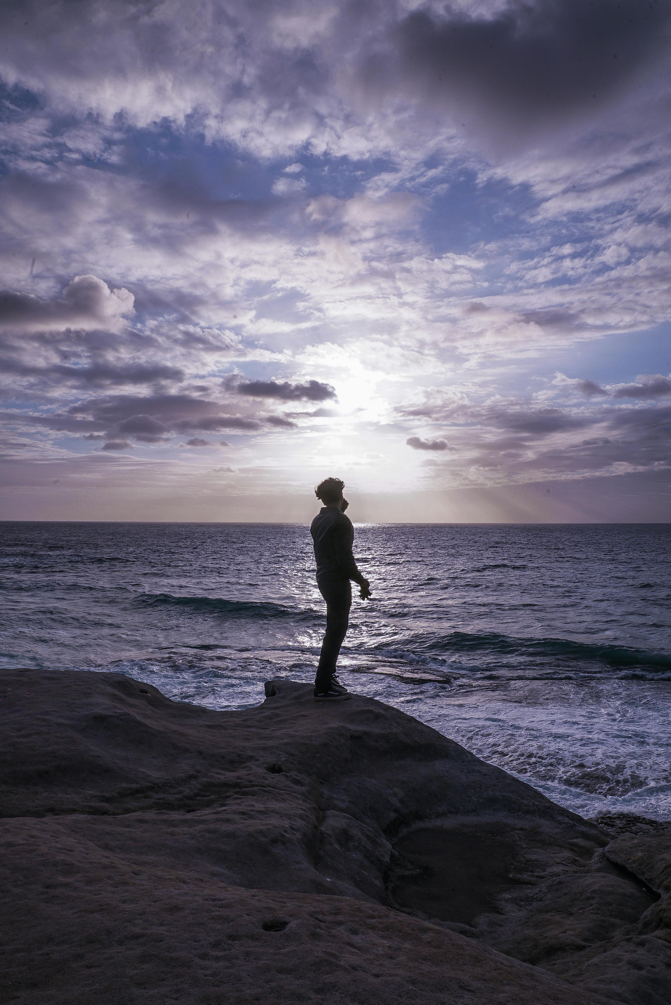 Photo Of Man Standing On Rock Formation · Free Stock Photo