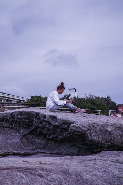 Foto Der Frau, Die Auf Felsen Sitzt