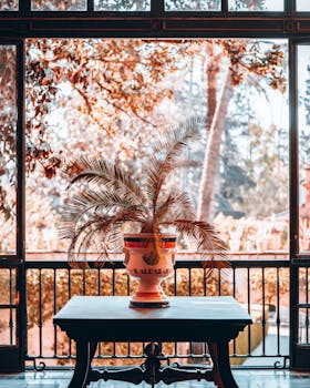 Elegant balcony view with Alcázar vase and plants in Seville, Spain.
