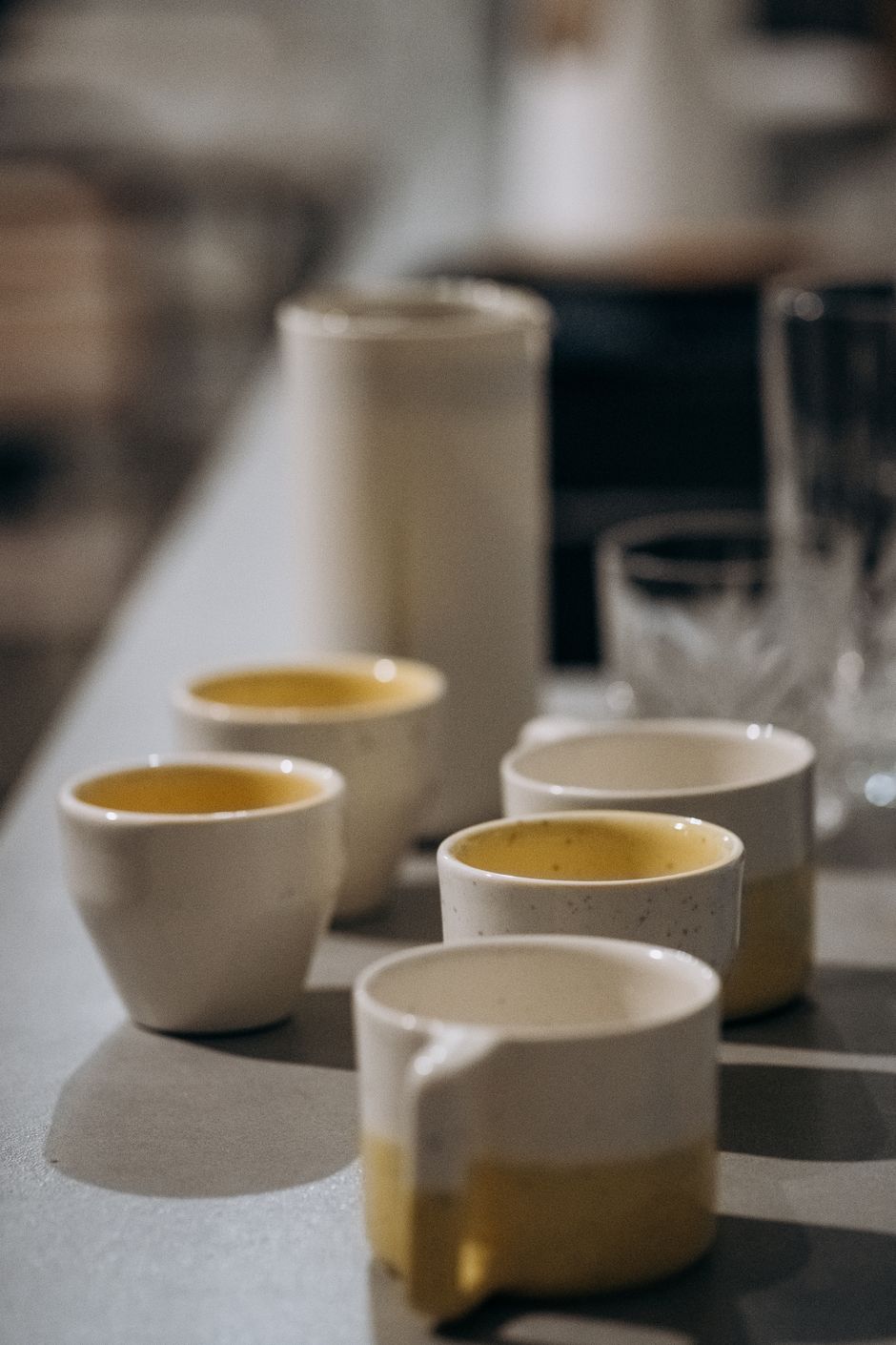 A stylish arrangement of ceramic cups and glassware on a modern kitchen counter.