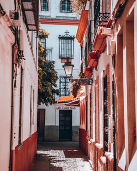 Explore a picturesque alleyway in Seville's historic district, capturing classic Spanish architecture.