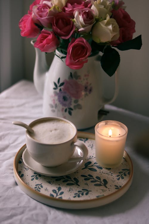 Coffee Cup Near Bouquet in Vase on Table