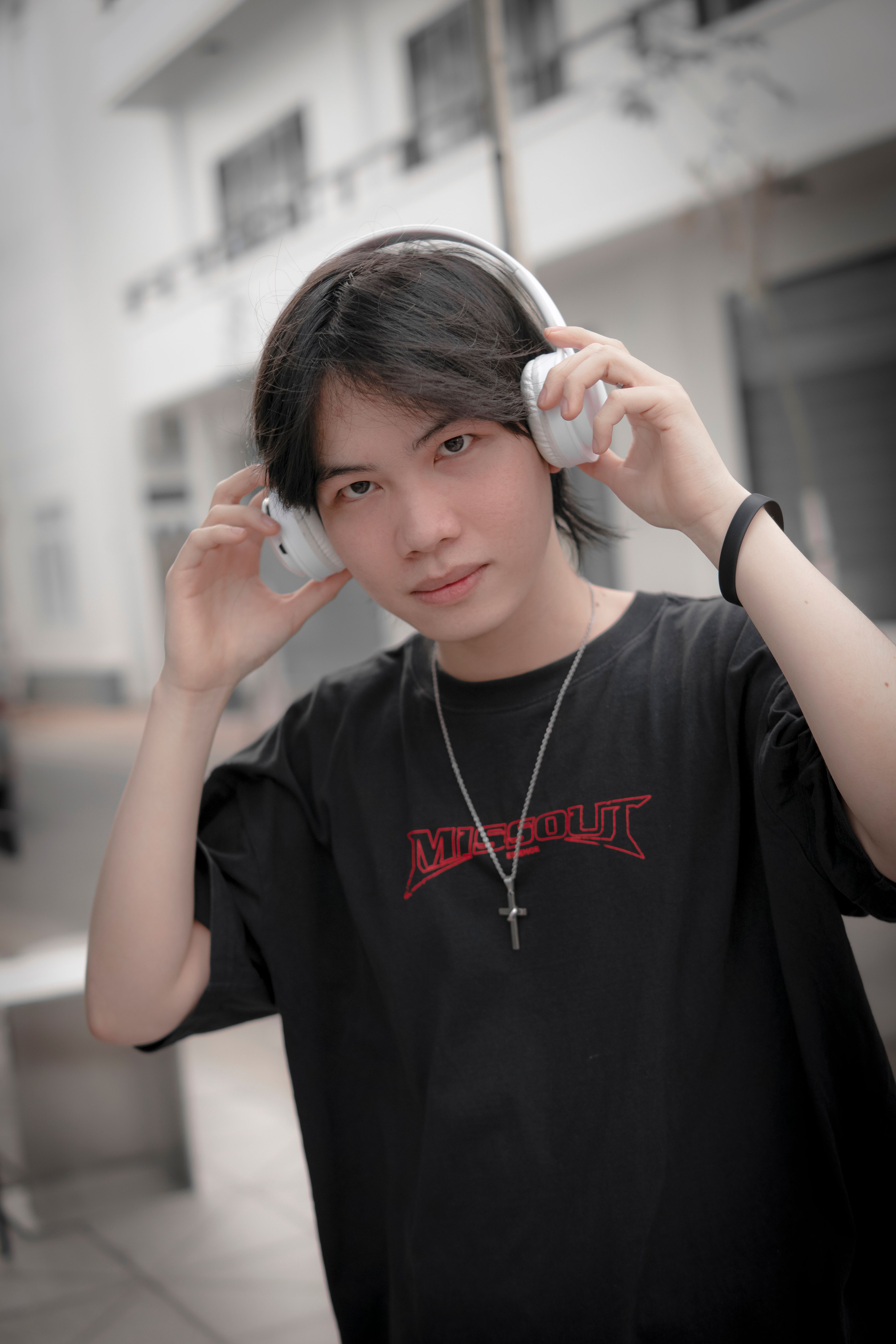 Casual portrait of a young man with headphones enjoying music in a stylish urban setting.