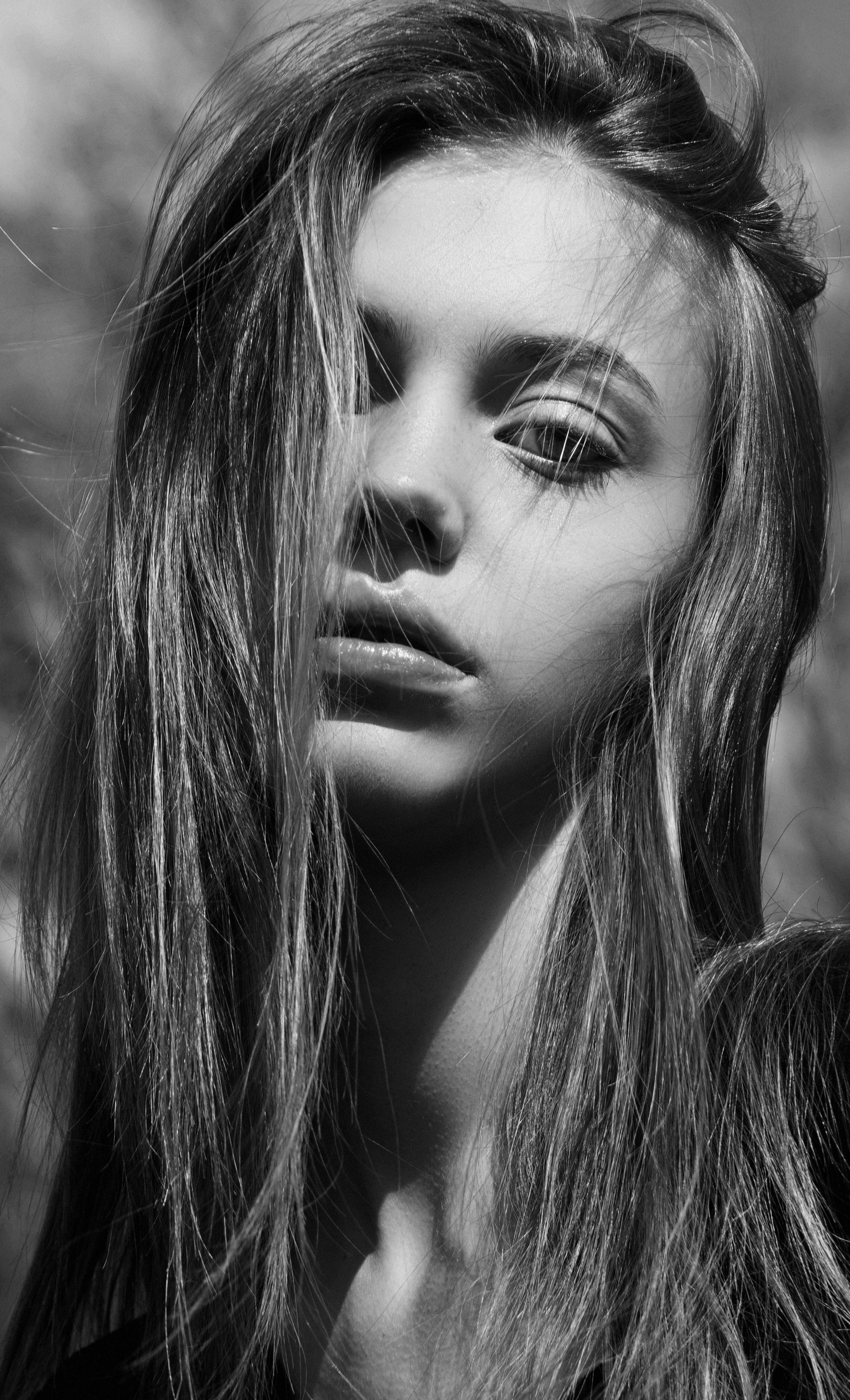 Striking black and white portrait of a young woman with natural, flowing hair.