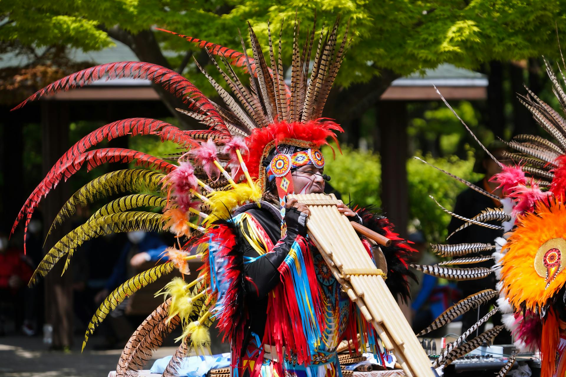 Un homme vêtu de vêtements traditionnels amérindiens joue de la musique lors d'un festival