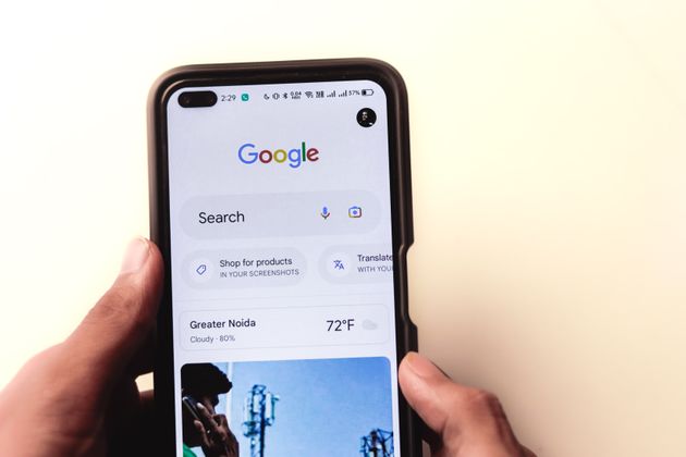 A customer holding a smartphone and searching on Google to learn more about a local business