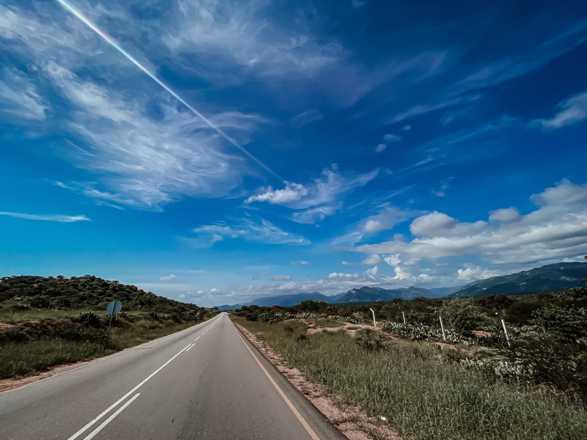 Beautiful countryside road in Angola with clear blue skies and mountain views.