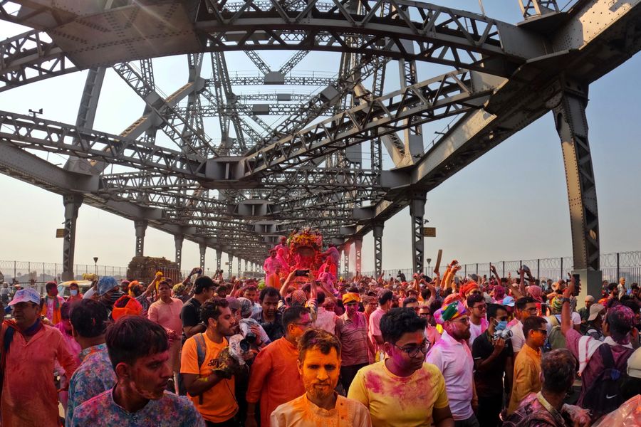 Colorful Holi festival celebration on Howrah Bridge, Kolkata, India with lively crowd