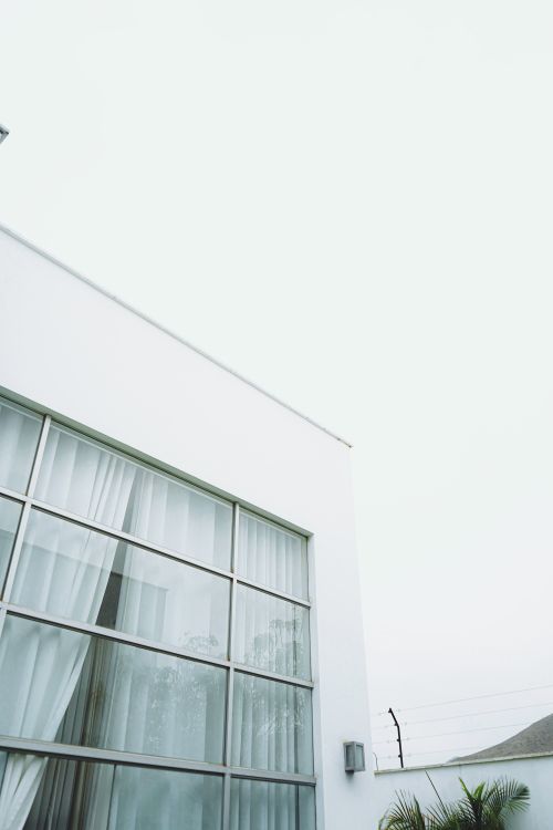 Free Low angle view of modern white building with large glass windows. Stock Photo