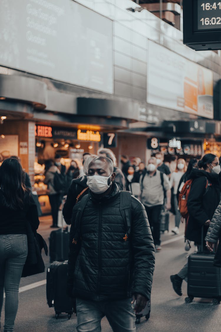 Man In Mask And Jacket Walking At Airport