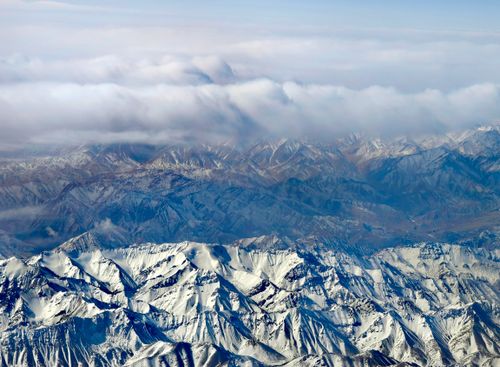 Free Stunning aerial shot of snow-covered mountains in Gansu, China, capturing winter's majestic beauty. Stock Photo