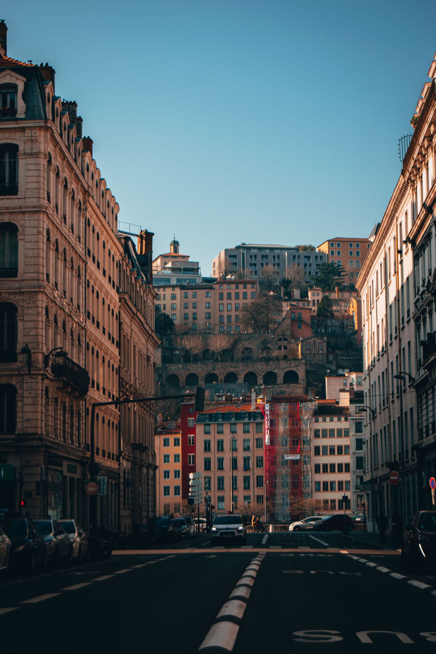 Une rue de Lyon bordée d'immeubles anciens sous un ciel dégagé