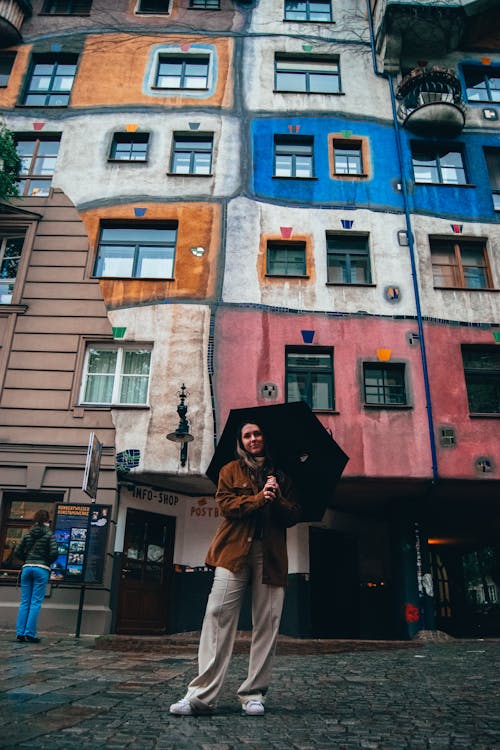 Woman with Umbrella Posing against Hundertwasser House in Vienna